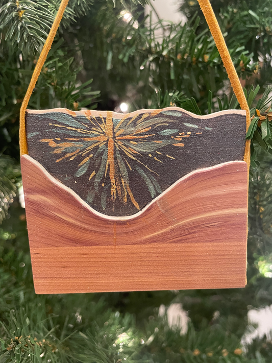 Wooden ornament with sunburst design hanging on a Christmas tree